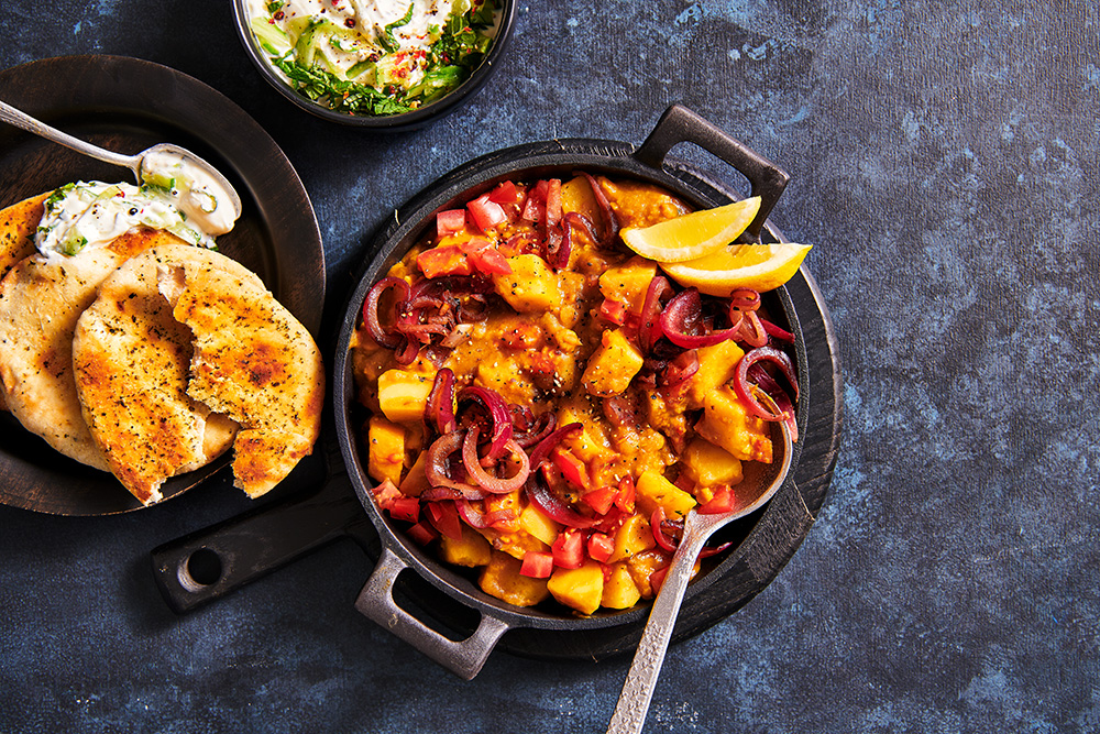 Dal tarka met trostomaten, aardappel en gekarameliseerde uitjes
