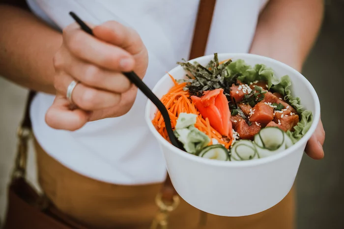 girl holding poke bowl